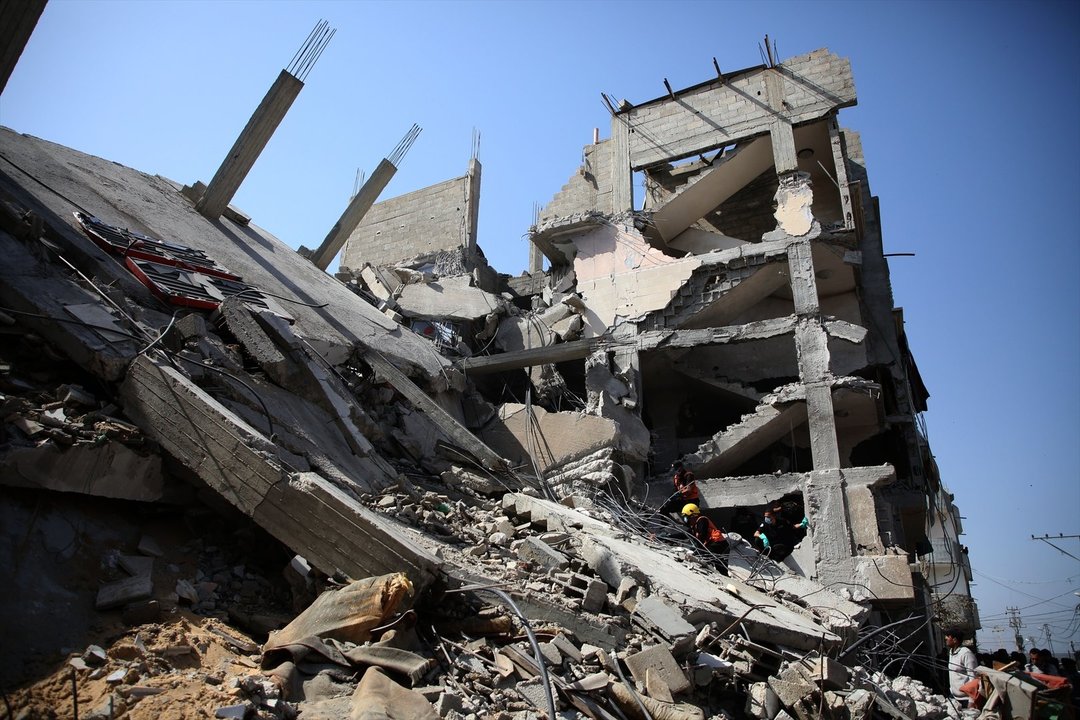 Palestinos buscan a posibles víctimas entre los escombros de un edificio bombardeado por el Ejército de Israel. // EP