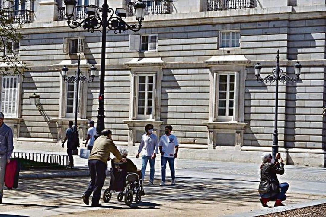 Una personaen silla de ruedas por una plaza de Madrid.