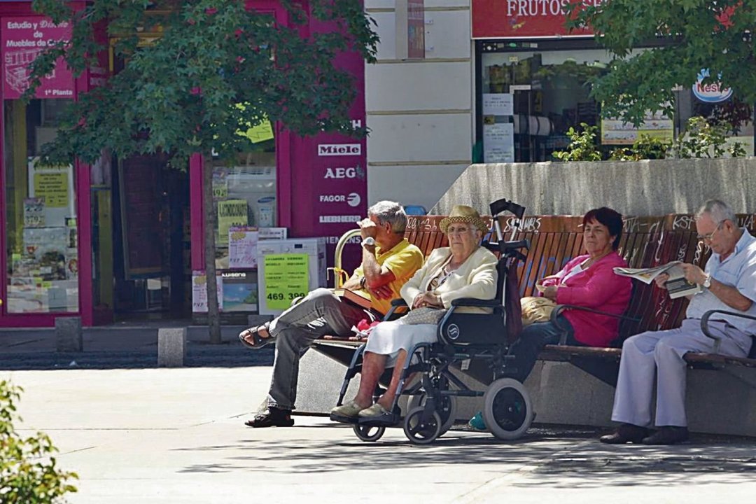 Cuatro personas mayores disfrutan del día en un parque.