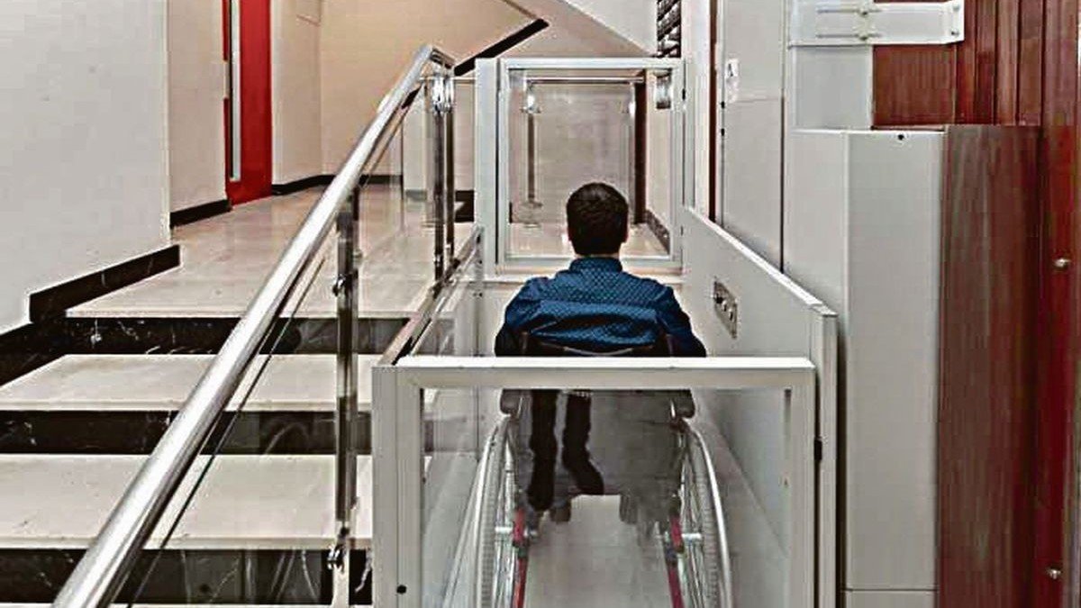 Una persona en silla de ruedas utilizando un elevador en un portal.