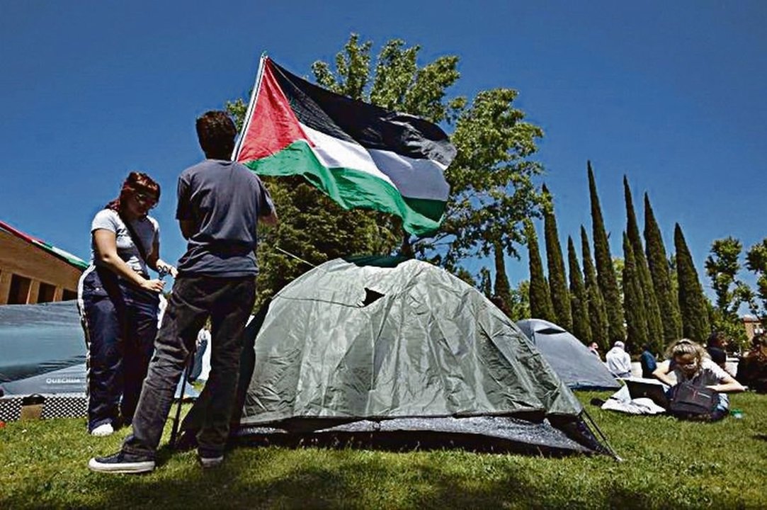 Dos estudiantes ponen una bandera palestina en señal de apoyo.