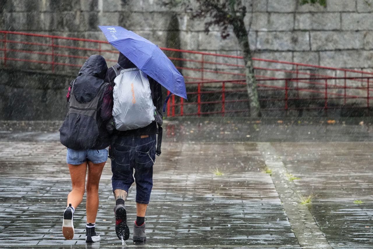 Dos personas se protegen de la lluvia en Vigo.